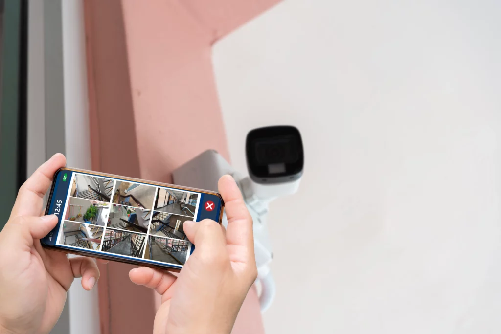person-hand-holding-smartphone-with-multiple-camera-views-office-locations-surveillance-modern-technology-blurred-background